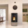 Poêle à granulés silencieux 12 kW Noris Plus, moderne et élégant, intégrée dans un intérieur chaleureux avec vue sur jardin.