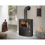 Poêle à bois Agero 2.0 Justus 7Kw Noir en fonctionnement dans un intérieur élégant avec bois de chauffage à côté.